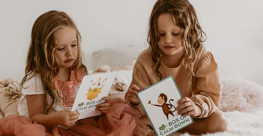 girls reading box of confidence cards